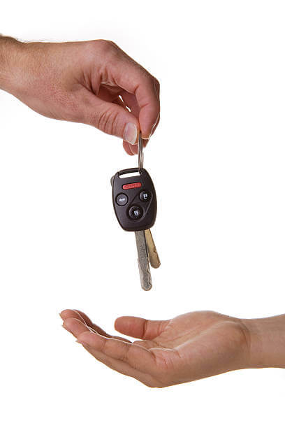 One hand drops a pair of car keys into another hand.